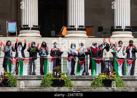 London, Großbritannien. Mai 2024. Studenten des University College London (UCL) halten während einer pro-palästinensischen Kundgebung zum Nakba-Tag die rot bemalten Hände hoch. Zwei weibliche Mitarbeiter der UCL und eine Alumna hatten sich früher die Köpfe rasiert, um palästinensische Frauen in Gaza zu unterstützen, die aufgrund fehlenden Wasserzugangs dazu gezwungen waren. Die Studenten der UCL richteten am 3. Mai ein pro-palästinensisches Lager auf dem Campus ein, um Druck auf die UCL auszuüben, akademische Partnerschaften mit Israel zu beenden und sich von Israel zu trennen. Quelle: Mark Kerrison/Alamy Live News Stockfoto