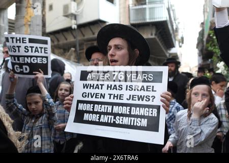 JERUSALEM - 14. MAI: Mitglieder von Neturei Karta, einer ultraorthodoxen jüdischen Randbewegung innerhalb des antizionistischen Blocks, halten palästinensische Fahnen und Zeichen gegen den Zionismus, während sie während einer Kundgebung gegen die Schaffung des Staates Israel durch die religiöse Nachbarschaft von MEA Shearim laufen. während Israel am 14. Mai 2024 in Jerusalem den 76. Unabhängigkeitstag feiert, während die Kämpfe zwischen Israel und der militanten Gruppe Hamas im Gazastreifen fortgesetzt werden. Neturei Karta lehnt den Zionismus ab und fordert eine "friedliche Zerschlagung" des Staates Israel, in dem Glauben, dass es Juden verboten ist, ihren eigenen Staat zu haben Stockfoto