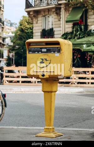 Paris, Frankreich - 1. Oktober 2023: Typischer gelber Pariser Briefkasten auf der Straße Stockfoto