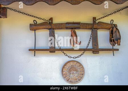 Traditionelle Objekte aus dem alten rumänischen Bauernhaushalt wie: Holzjoch für Ochsen, Lederschuhe genannt opinci, Tonrad und Metallketten, verwendeten A Stockfoto