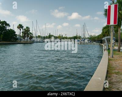 Weiter Blick nach Norden in die City of Gulfport Municipal Marina. Ruhiges blaues Wasser mit einem kleinen Boot. Wellige Wellen. Bootsanlegestelle, Holzpfähle und Boote Stockfoto