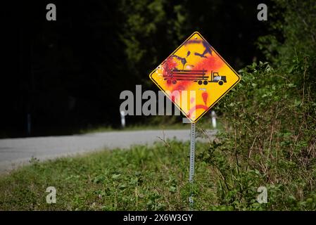 Ein Schild, das den Einsatz von Holzfällern auf einer Straße zwischen Lake Cowichan und Port Refrew in British Columbia, Kanada, warnt, wurde durch einen Anti-Lo-Mechanismus beschädigt Stockfoto