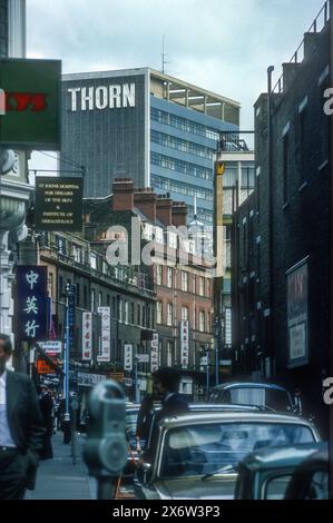 1976 Archivbild der Aussicht entlang der Lisle Street in Soho's Chinatown, London, vor der Fußgängerzone. Das Thorn House (heute Orion House), entworfen von Basil Spence & Partners, in der Upper St Martins Lane ist im Hintergrund. Stockfoto