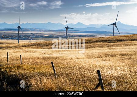 Windturbinen überblicken die Stadt Pincher Creek Alberta und den Crowsnest Pass mit den Rocky Mountains im Hintergrund im Westen Kanadas. Stockfoto