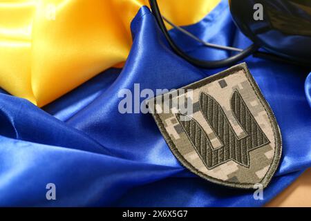 Abzeichen der ukrainischen Armee mit Dreizack auf ukrainischer Flagge, Nahaufnahme Stockfoto