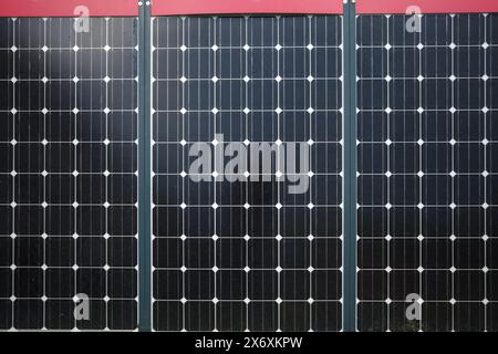 Ein detailliertes Nahbild von drei in einer Reihe angeordneten Solarpaneelen, die das komplizierte Design der Photovoltaikzellen erfassen. Stockfoto