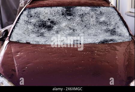 Hagelschaden an einem Auto. Große Hagelsteine haben ein Auto komplett zerstört Stockfoto