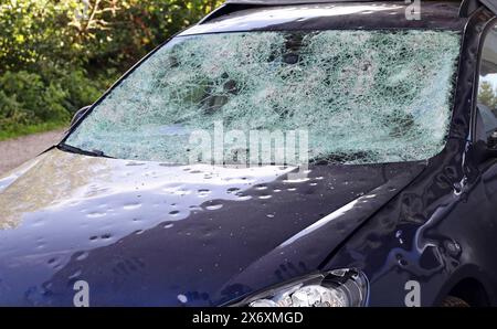 Hagelschaden an einem Auto. Große Hagelsteine haben ein Auto komplett zerstört Stockfoto