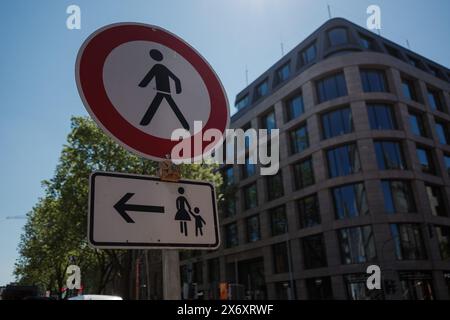 Das runde rote Schild weist auf eine Fußgängerzone hin, während das rechteckige Schild unten Familien zu einem sicheren Überquerungsbereich weist. Stockfoto