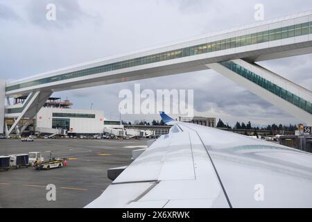 SeaTac, WA, USA - 4. März 2024; moderne Skybridge für internationale Ankünfte am Flughafen Seatac über dem Flugzeugflügel Stockfoto