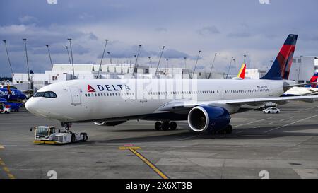 SeaTac, WA, USA - 4. März 2024; Delta Air Lines Airbus A330-900 schiebt vom Gate mit Schlepper am Flughafen zurück Stockfoto