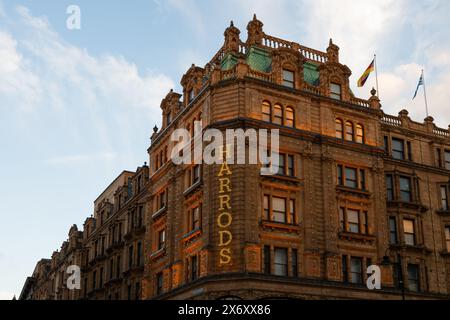 London, Großbritannien - 22. März 2024; Detail des Schilds des Kaufhauses Harrods, beleuchtet an der Fassade im Abendlicht Stockfoto