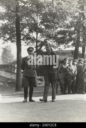 Deutsche Kriegsgefangene, deutsche Kriegsgefangene, die von Engländern bewacht werden? Soldaten. Links ein hochrangiger Offizier der Luftwaffe, daneben ein alliierter Soldat. Kriegsgefangene im Hintergrund, Foto, anonym, Niederlande, Mai 1945, fotografischer Träger, Höhe, 13 cm x Breite, 17,5 cm Stockfoto