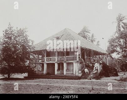 Zwei Männer sitzen in ihren weißen tropischen Anzügen auf dem Bürgersteig eines Hauses in der Nähe von Kalianget., bei Kalianget 1914 (Titel auf Objekt), Photographies (Titel der Serie), Foto aus Album 'Photographies'., Foto, Frits Freerks Fontein Fz., (zugeschrieben), Frits Freerks Fontein Fz., (zugeschrieben), Madura, (möglicherweise), Niederlande, (möglicherweise), ca. 1912, Karton, Höhe, 57 mm x Breite, 128 mm, Höhe, 242 mm x Breite, 333 mm Stockfoto