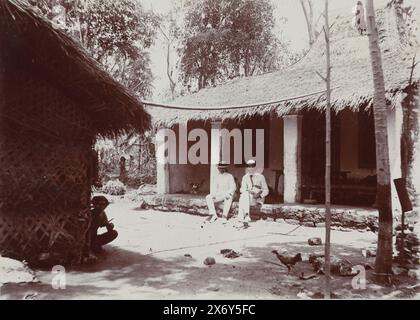 Zwei Männer sitzen in ihren weißen tropischen Anzügen auf dem Bürgersteig eines Hauses in der Nähe von Kalianget., in der Nähe von Kalianget (Titel auf Objekt), Photographies (Titel der Serie), Foto aus Album 'Photographies'., Foto, Frits Freerks Fontein Fz., (zugeschrieben), Frits Freerks Fontein Fz., (zugeschrieben), Madura (möglicherweise), Niederlande, (möglicherweise), ca. 1912, Karton, Höhe, 57 mm x Breite, 128 mm, Höhe, 242 mm x Breite, 333 mm Stockfoto