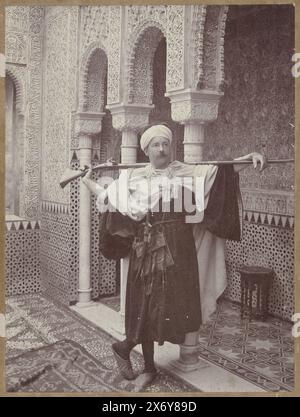 Atelierporträt von Henry Pauw van Wieldrecht in orientalischer Tracht mit Gewehr. Im Mosaikboden des Ateliers im Stil der Alhambra ist ein Teil des Namens des Fotografen zu lesen: Rafael G[arzón]., Foto, Rafael Garzón, Henry Pauw van Wieldrecht, Granada, Niederlande, 1902, fotografischer Träger, Höhe, 217 mm x Breite, 162 mm, Höhe, 267 mm x Breite, 197 mm Stockfoto