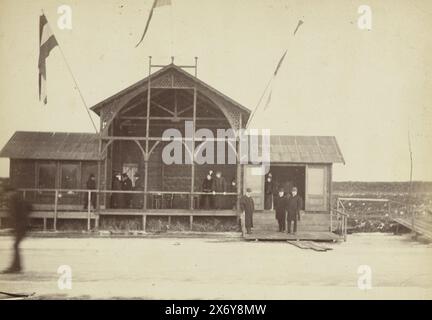 Clubgebäude des Eisclubs Utrecht, Clubgebäude des Eisclubs Utrecht mit schwenkender Flagge. Vor dem Gebäude stehen eine Reihe von Männern in Bowler-Hüten und langen Mänteln. Mit Bildunterschrift: IJsclub Utrecht., Foto, Henry Pauw van Wieldrecht, (zugeschrieben), Niederlande, 1888, Papier, Albumendruck, Höhe, 172 mm x Breite, 122 mm, Höhe, 302 mm x Breite, 250 mm Stockfoto