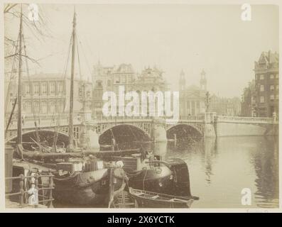 Blauwbrug mit der Moses- und Aaron-Kirche im Hintergrund, Blauwbrug (Titel auf Objekt), Teil des Fotoalbums mit Aufnahmen des Amsterdamer Zentrums und Werbetexten für Geschäfte und Unternehmen., Foto, anonym, Amsterdam, ca. 1880 - ca. 1895, fotografischer Träger, Albumendruck, Höhe, 201 mm x Breite, 270 mm Stockfoto