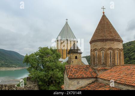 Malerischer Blick auf die Ananuri Festung Komplex mit türkisfarbenem Wasser des Zhinvali Reservoir umgeben von Bergen auf dem georgischen Militär Stockfoto