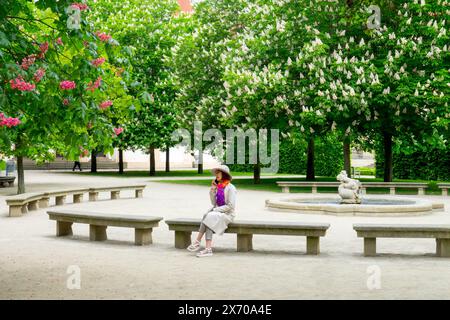 Frau sitzt auf Steinbank im Garten des Wallenstein Parks Prag Mala Strana Stockfoto