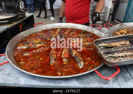 Fisch wird in einer riesigen Pfanne auf einem Outdoor Food Festival gekocht. Stockfoto