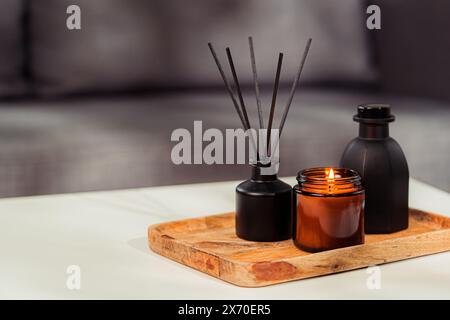 Aromatischer Schilferfrischer und Kerze auf dem Tisch im Zimmer Stockfoto