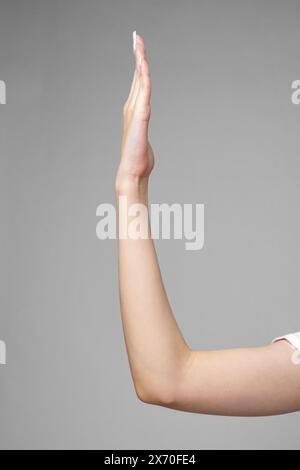 Weibliches Handzeichen auf grauem Hintergrund Stockfoto