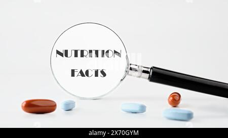 Viele Nutrition Facts-Texte, geschrieben durch eine Lupe auf hellem Hintergrund. Konzeptfoto Stockfoto