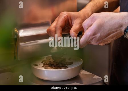 Küchenchef Reiben Trüffel - Gourmet-Gericht - feine Küche - kulinarische Kunst, luxuriöse Zutaten - High-End-Restaurant, professionelle Küche. Stockfoto