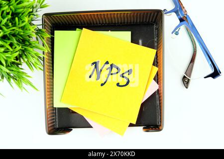 Concept Word NPS Net Promoter Score auf einem gelben Aufkleber in einem Ständer auf weißem Hintergrund, Draufsicht Stockfoto