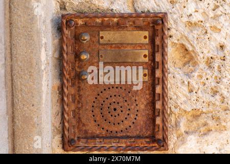 Alte Gegensprechanlage an verwitterter Steinmauer Stockfoto