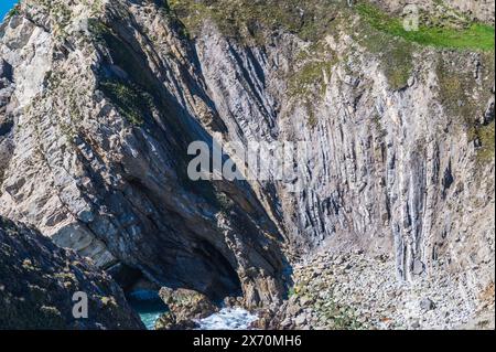 Lulworth zerknittert die Felsformation in Stair Hole, Dorset, England, an einem sonnigen Apriltag mit blauem Himmel, gefalteten Kalksteinschichten Stockfoto