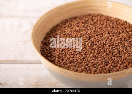 Buchweizengrieß auf einem Holzteller auf einem hölzernen Hintergrund. Stockfoto