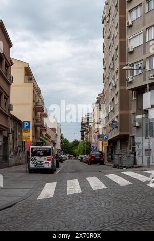 Wohnstraße in Belgrad, Mischung aus Baustilen und geparkten Fahrzeugen. April 2024. Stockfoto