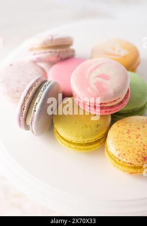 Mehrfarbige Macarons auf Holzhintergrund mit sanften Lichtern und Schatten. Sanfte Makronen auf dem Tisch auf hellem Hintergrund. Stockfoto