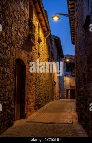 Straße des historischen mittelalterlichen Zentrums von Santpedor beleuchtet bei Nacht und in der blauen Stunde (Bages, Barcelona, ​​Catalonia, Spanien) Stockfoto