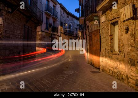 Straße des historischen mittelalterlichen Zentrums von Santpedor beleuchtet bei Nacht und in der blauen Stunde (Bages, Barcelona, ​​Catalonia, Spanien) Stockfoto