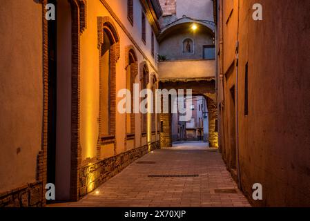 Straße des historischen mittelalterlichen Zentrums von Santpedor beleuchtet bei Nacht und in der blauen Stunde (Bages, Barcelona, ​​Catalonia, Spanien) Stockfoto