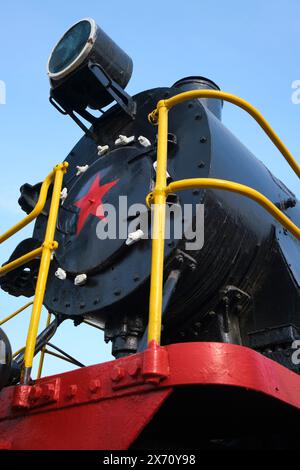 View of the front of an old steam, black locomotive with red star and light. At the Railway Museum, a collection of Soviet, Russian era trains, locomo Stockfoto