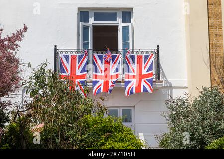Drei Union Jack Flaggen hängen von einem Hausbalkon Stockfoto