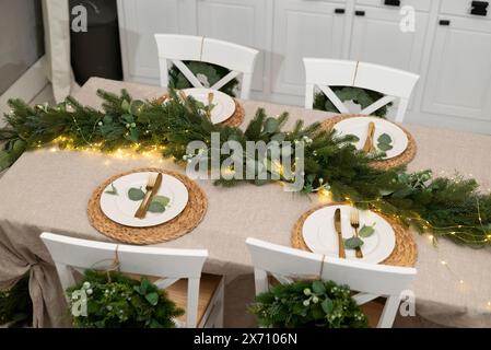 Weihnachtliche Kücheneinrichtung und Tischeinrichtung. Rustikale Küche zu Weihnachten. Details der skandinavischen Küche in Goldfarbe. Küche Insel festlich. Stockfoto