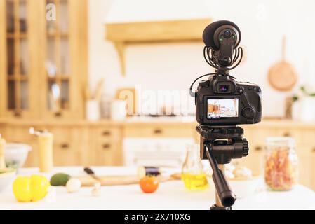 Stilvolle Küche mit minimalistischem Interieur. Professionelle Kamera macht Fotos von verschwommener Küche bei Tageslicht. Food-Blog. Stockfoto