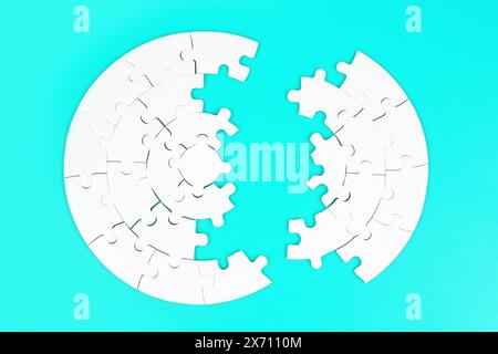 Draufsicht eines leeren kreisförmigen Puzzles, das in zwei Teile auf hellblauem Hintergrund aufgeteilt ist. Stockfoto