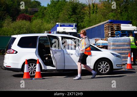 Leute sammeln Wasser in Flaschen auf dem Broadsands Parkplatz in Paignton. Rund 16.000 Haushalten und Unternehmen in der Region Brixham in Devon wurde gesagt, ihr Leitungswasser nicht zu trinken, ohne es zuerst zu kochen und zu kühlen, nachdem kleine Spuren eines Parasiten im lokalen Wassernetz entdeckt wurden. Bilddatum: Freitag, 17. Mai 2024. Stockfoto