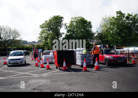 Leute sammeln Wasser in Flaschen auf dem Broadsands Parkplatz in Paignton. Rund 16.000 Haushalten und Unternehmen in der Region Brixham in Devon wurde gesagt, ihr Leitungswasser nicht zu trinken, ohne es zuerst zu kochen und zu kühlen, nachdem kleine Spuren eines Parasiten im lokalen Wassernetz entdeckt wurden. Bilddatum: Freitag, 17. Mai 2024. Stockfoto