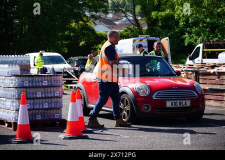 Leute sammeln Wasser in Flaschen auf dem Broadsands Parkplatz in Paignton. Rund 16.000 Haushalten und Unternehmen in der Region Brixham in Devon wurde gesagt, ihr Leitungswasser nicht zu trinken, ohne es zuerst zu kochen und zu kühlen, nachdem kleine Spuren eines Parasiten im lokalen Wassernetz entdeckt wurden. Bilddatum: Freitag, 17. Mai 2024. Stockfoto