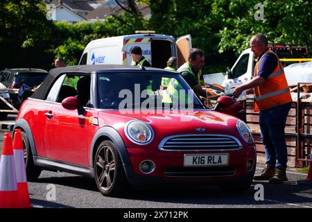 Leute sammeln Wasser in Flaschen auf dem Broadsands Parkplatz in Paignton. Rund 16.000 Haushalten und Unternehmen in der Region Brixham in Devon wurde gesagt, ihr Leitungswasser nicht zu trinken, ohne es zuerst zu kochen und zu kühlen, nachdem kleine Spuren eines Parasiten im lokalen Wassernetz entdeckt wurden. Bilddatum: Freitag, 17. Mai 2024. Stockfoto