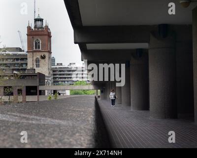 Barbican Highwalk auf dem Barbican Estate mit St. Giles Cripplegate im Hintergrund Stockfoto