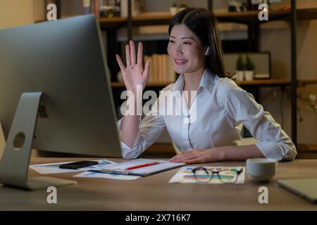 Die junge Frau arbeitet und trifft sich bis spät in die Nacht mit ihrem Team Stockfoto