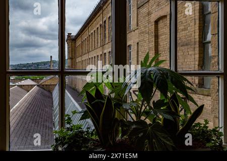 Blick vom Fenster im zweiten Stock von Salts Mill in Saltaire. Der Blick blickt über das Dach des unteren Stockwerks in Richtung Wrose. Stockfoto